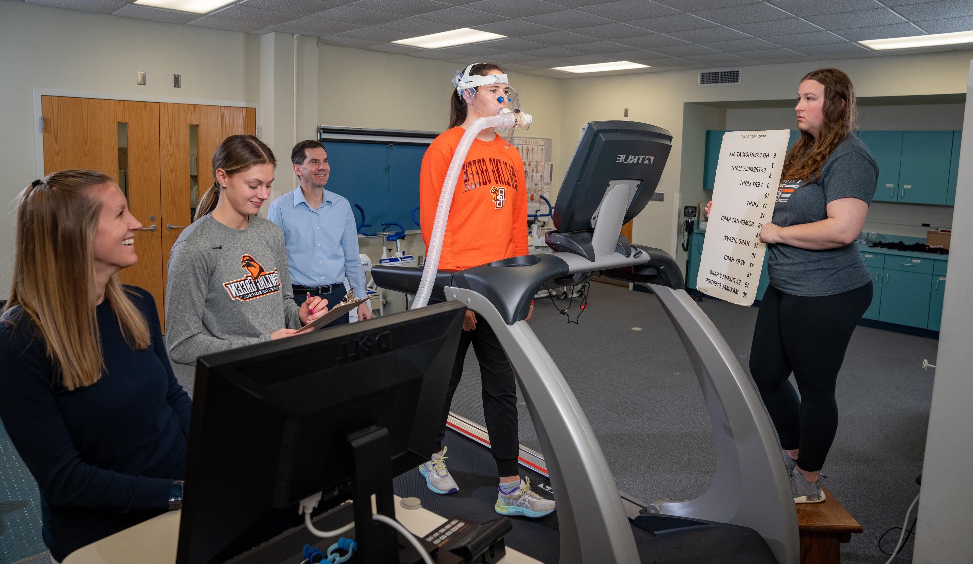 在俄亥俄州校园的运动生理学实验室里，BGSU运动机能学硕士项目的学生们聚集在一个在跑步机上跑步的学生身边，测量他的耗氧量.