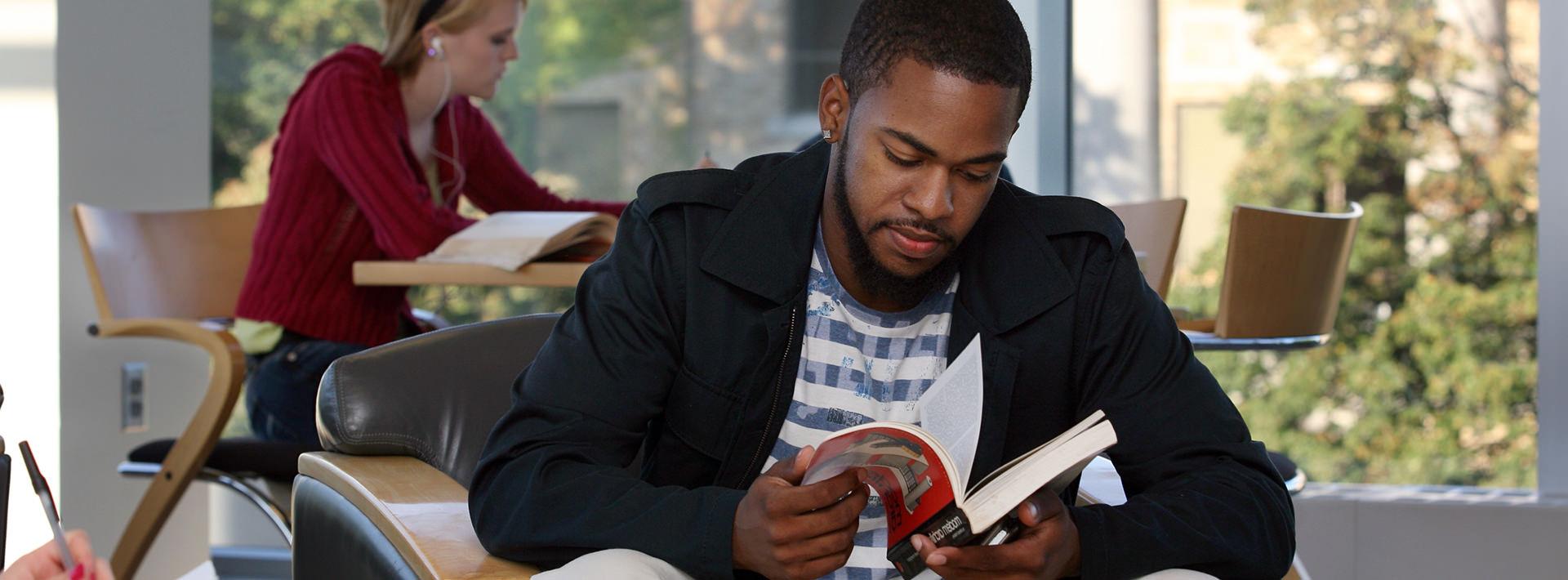 A male student flipping through a book.